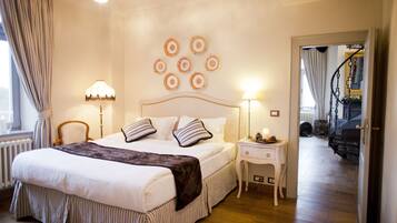 A bedroom with a large bed, two bedside tables with lamps, a chair, and a wall with circular decorations.