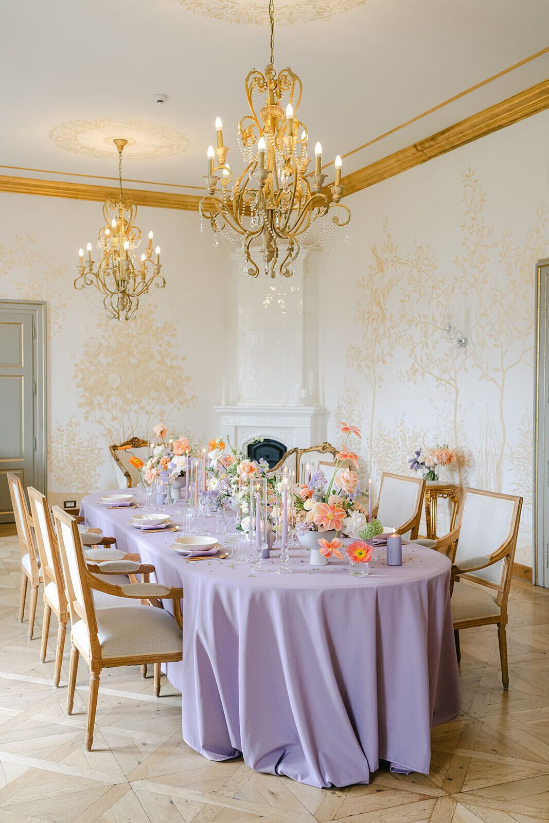 A formal dining room with a round table, elegant chairs, and a chandelier.