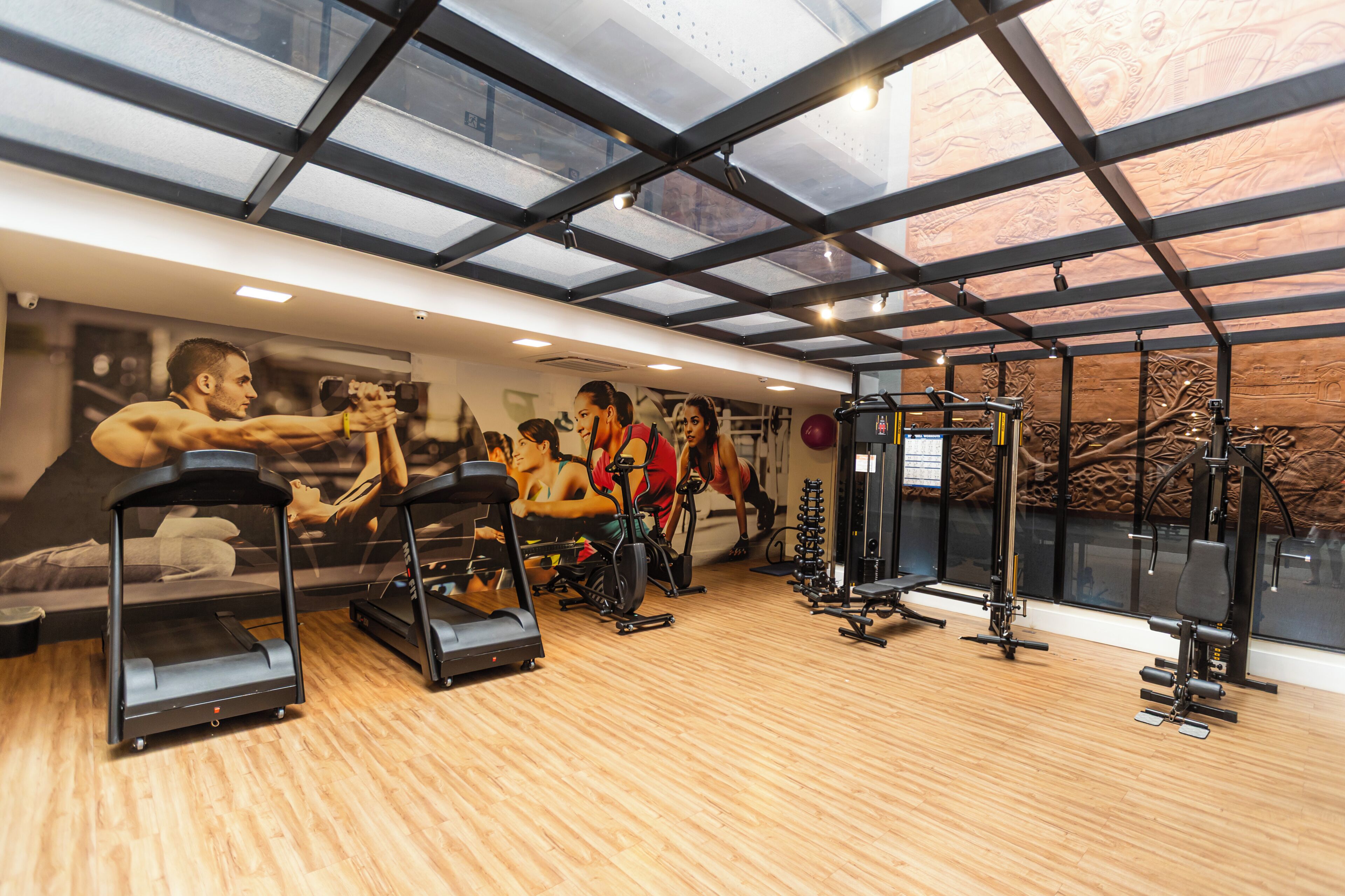 A gym with treadmills, exercise bikes, and weight machines.
