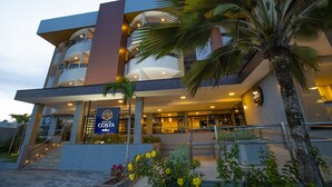 A modern hotel with a prominent sign, multiple balconies, and a palm tree in the foreground. - Hotel da Costa by Nobile (Aracaju)