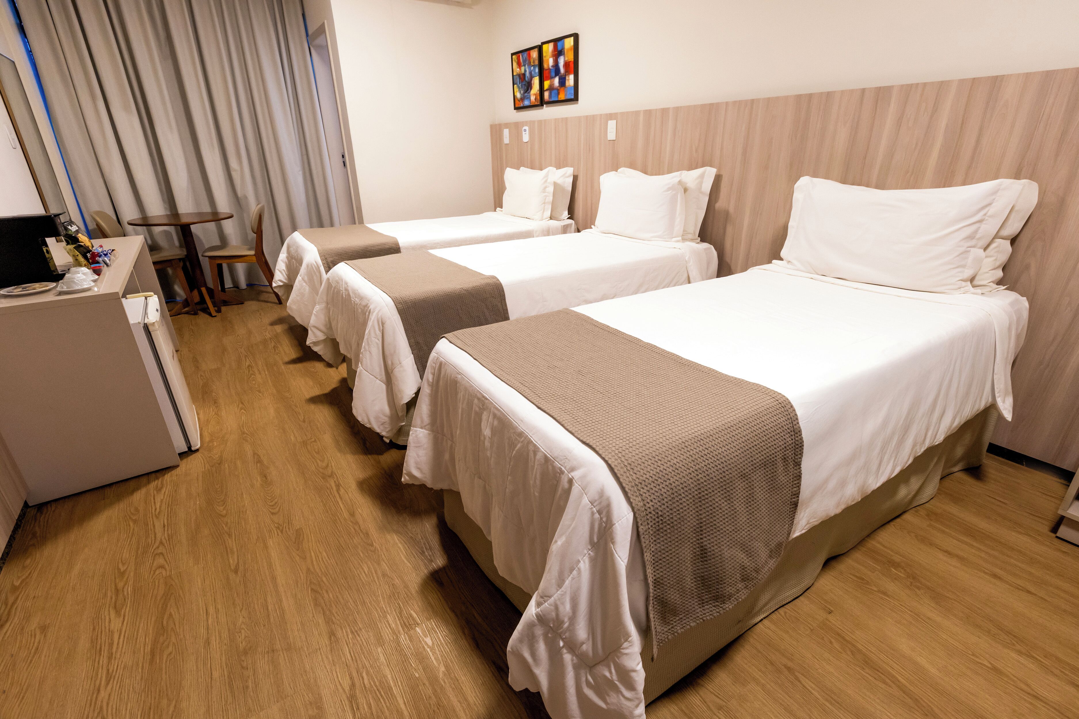 Una habitación de hotel con dos camas, un escritorio y una silla.