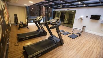 A gym with treadmills, a stationary bike, and a weight rack.