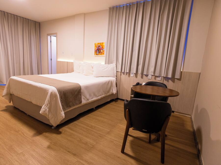 Una habitación de hotel con una cama, un escritorio y una silla.