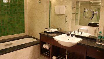 Une salle de bain avec une baignoire, un lavabo et un miroir.