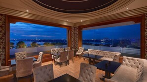 A luxurious lounge area with plush seating and large windows offering a city view. - Hyderabad Marriott Hotel & Convention Centre (Hyderabad)