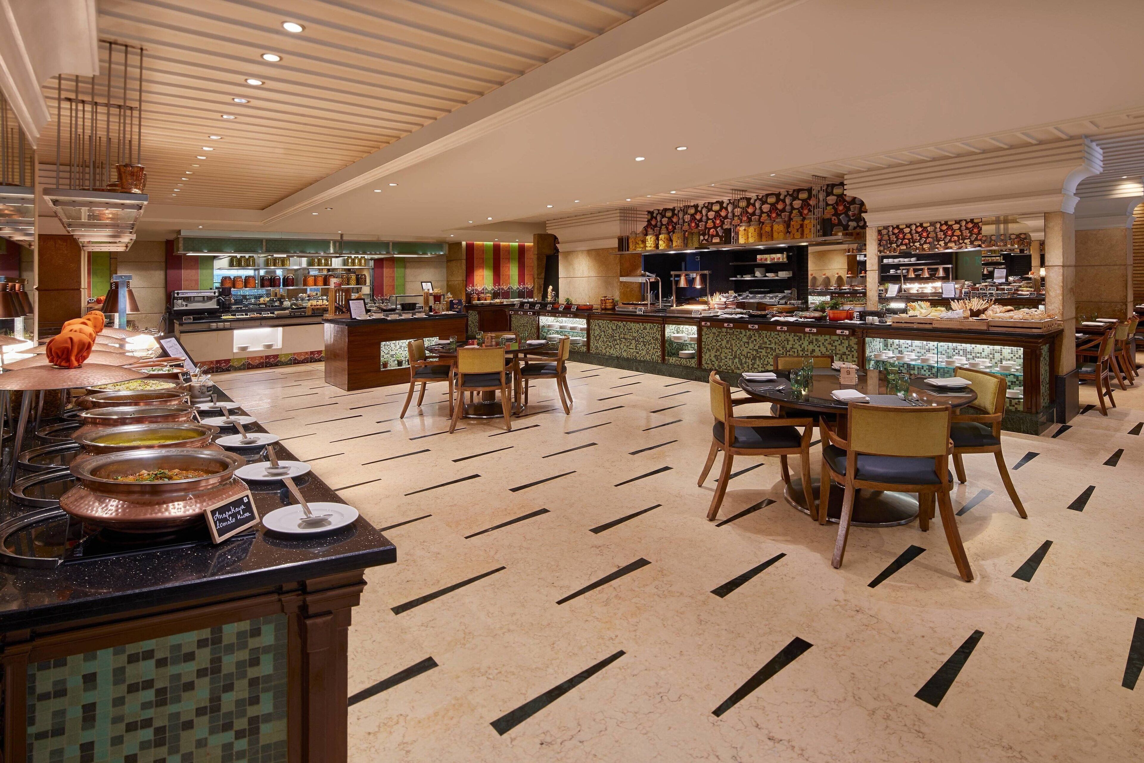 A buffet area with multiple serving stations, a central bar, and seating arrangements.