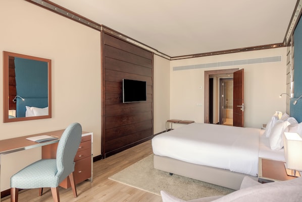 A hotel room with a bed, desk, chair, and a television. - Sesimbra Oceanfront Hotel - Preferred Hotels and Resorts (Sesimbra)