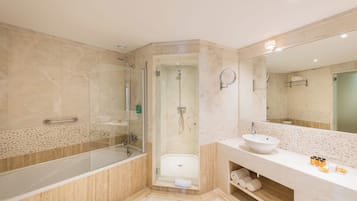 A modern bathroom with a glass-enclosed shower, a white sink, and a large mirror.
