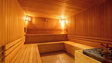 A wooden sauna with benches and a heated floor, featuring a wooden ceiling and walls.