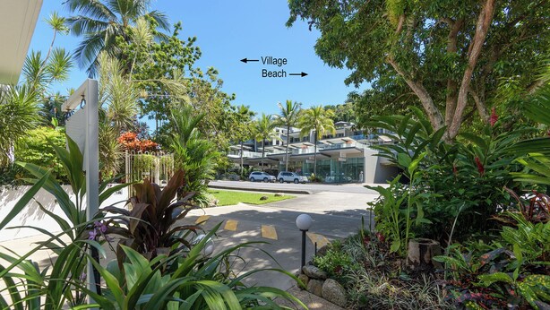 A modern building with a paved driveway and lush greenery. - Port Douglas Apartments - Adults Only Oasis (Port Douglas)