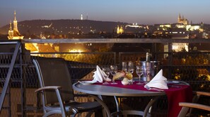 Mesa para dos con vista a un paisaje urbano al anochecer.
