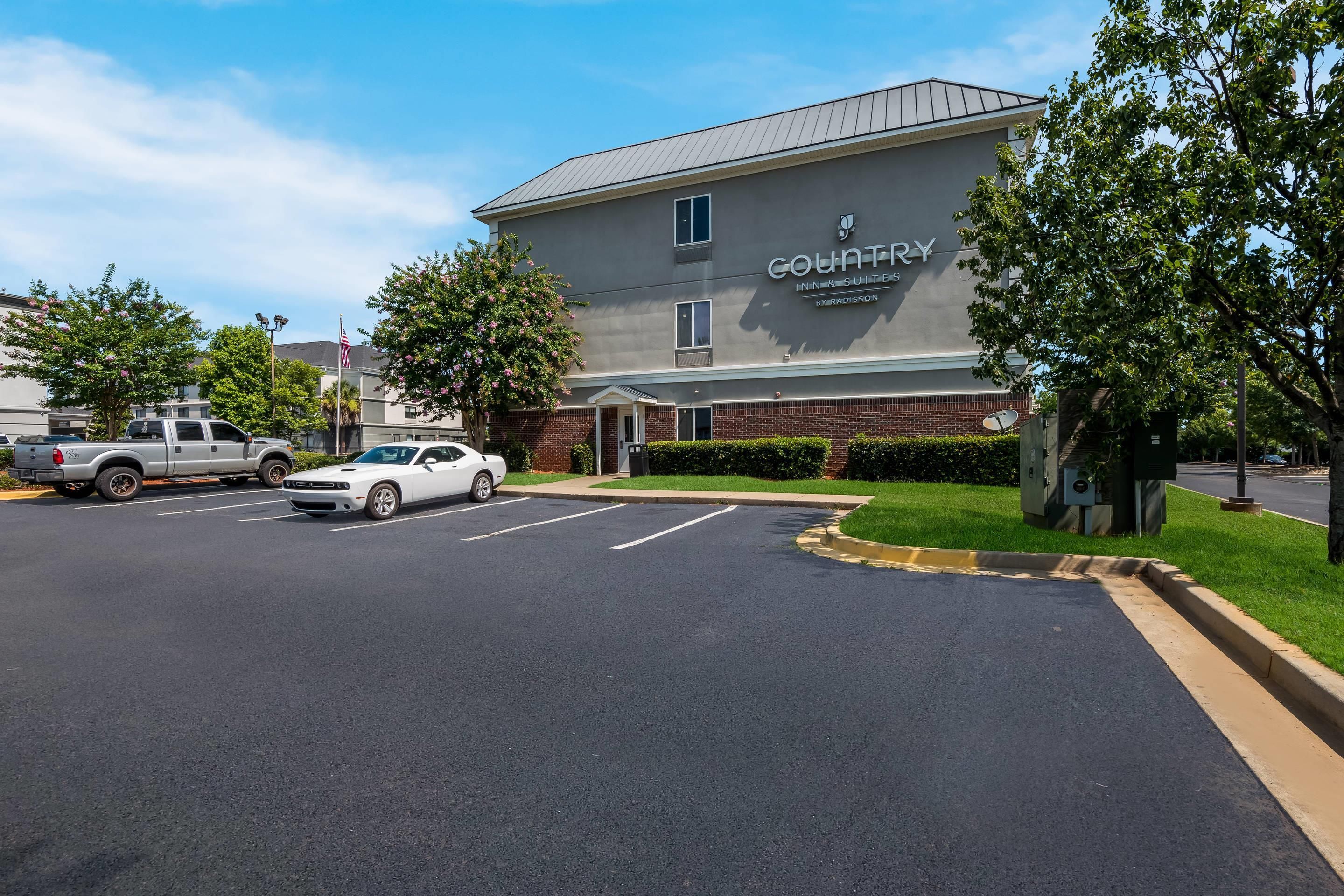 Ein Gebäude mit der Aufschrift 'COUNTRY INN & SUITES BY RADISSON' und einem Parkplatz davor.