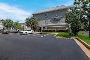 En bygning med skilt for 'COUNTRY INN & SUITES BY RADISSON' og en parkeringsplads foran.