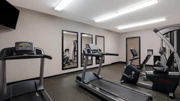A gym with treadmills, elliptical machines, and weight equipment.
