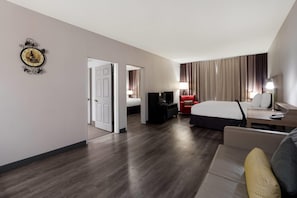 A hotel room with a bed, a desk, a TV, a red chair, and a lamp. - Country Inn & Suites by Radisson, Augusta at I-20, GA (Augusta)
