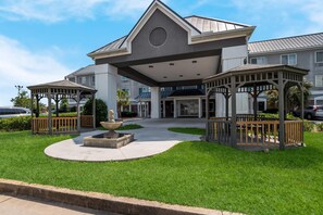 A modern building with a central entrance, two covered gazebos, and a fountain in the courtyard. - Country Inn & Suites by Radisson, Augusta at I-20, GA (Augusta)