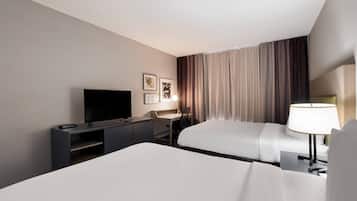 Une chambre d’hôtel avec un lit, un bureau, une télévision et une lampe.