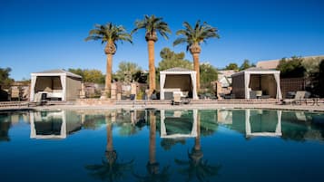 Una piscina al aire libre, sillones reclinables de piscina