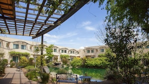 A courtyard with a pond, benches, and a pergola. - DoubleTree by Hilton Napa Valley - American Canyon (American Canyon)