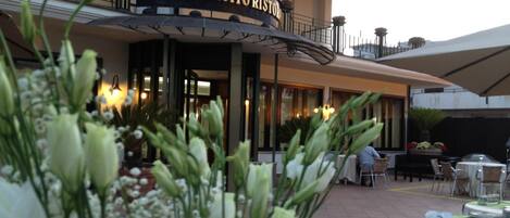 The exterior of Hotel Belsito Ristorante with outdoor seating and a sign above the entrance.