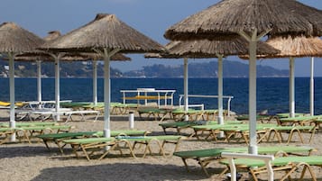 Una playa cerca, arena blanca, sillas reclinables de playa