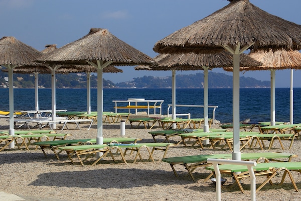 Pantai di sekitar, pasir putih, kursi berjemur, dan bar pantai