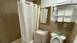 Een badkamer met een bad, een wastafel, een toilet, een spiegel en een handdoekhouder.