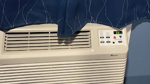 Een airconditioner met een bedieningspaneel waarop temperatuurinstellingen staan.
