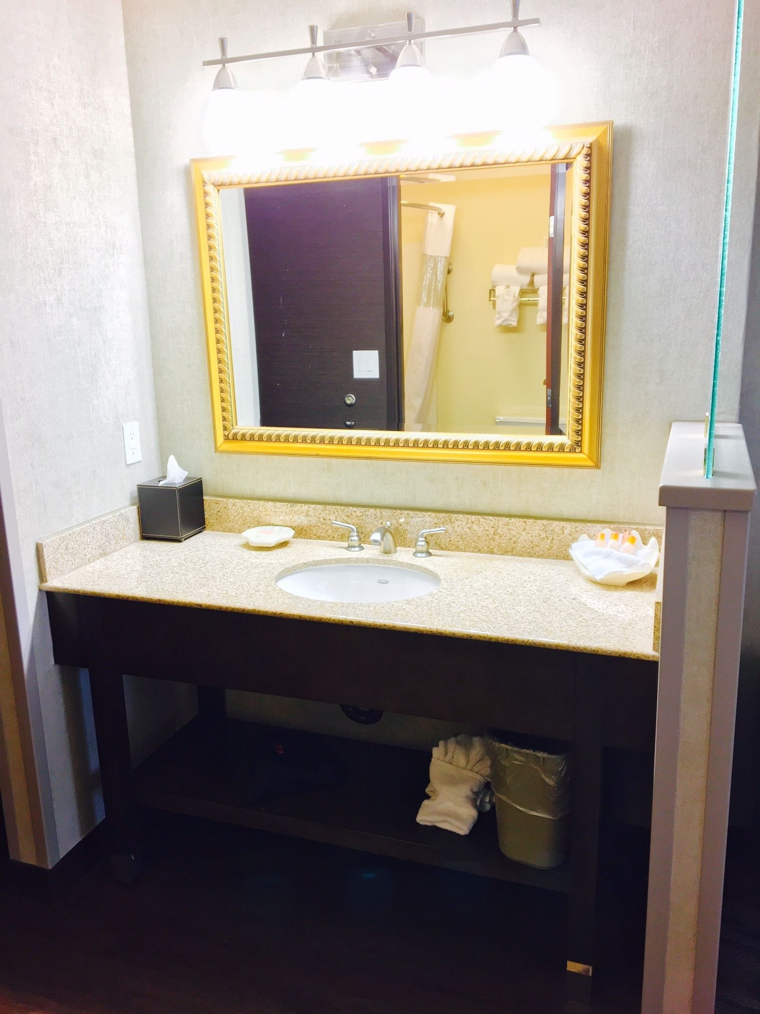A bathroom with a sink, mirror, and towel rack.