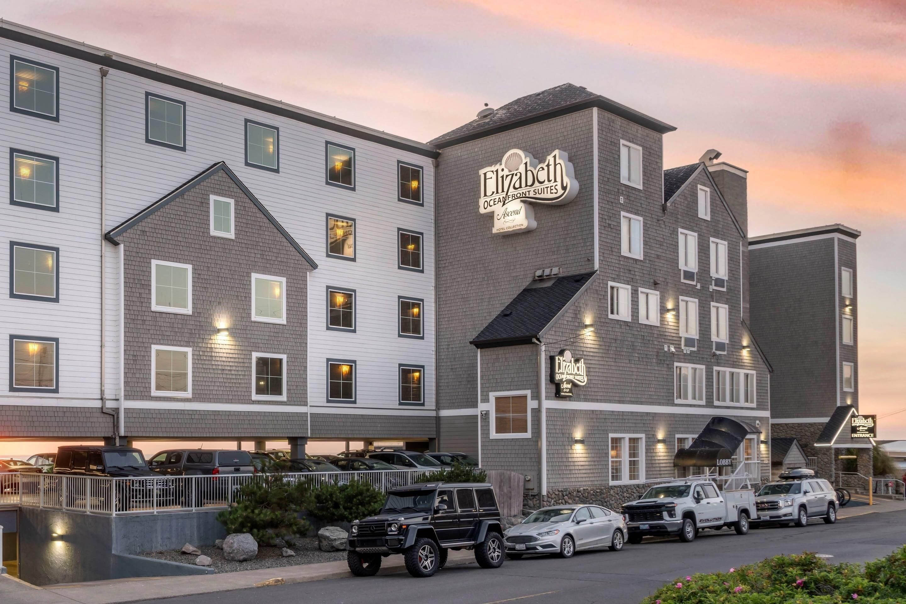 Un hotel de varios pisos con un letrero llamativo que dice 'Elizabeth Oceanfront Suites'.