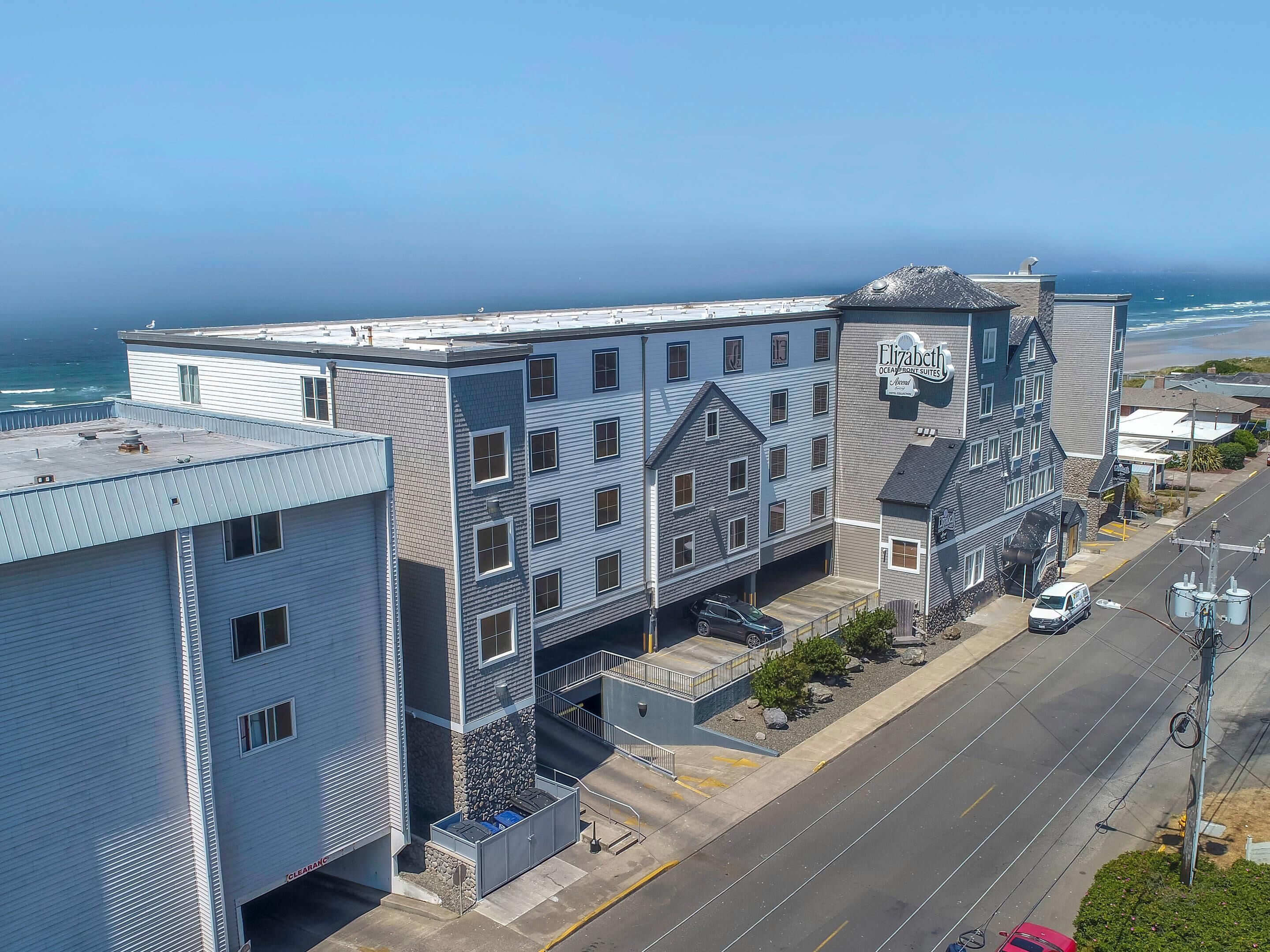 Een meerlaags gebouw met een opvallend bord waarop 'Elizabeth Oceanfront Suites' staat.