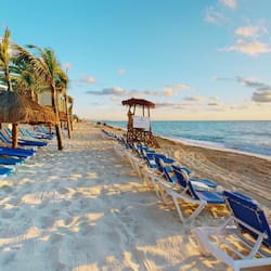 On the beach, white sand, sun loungers, beach umbrellas