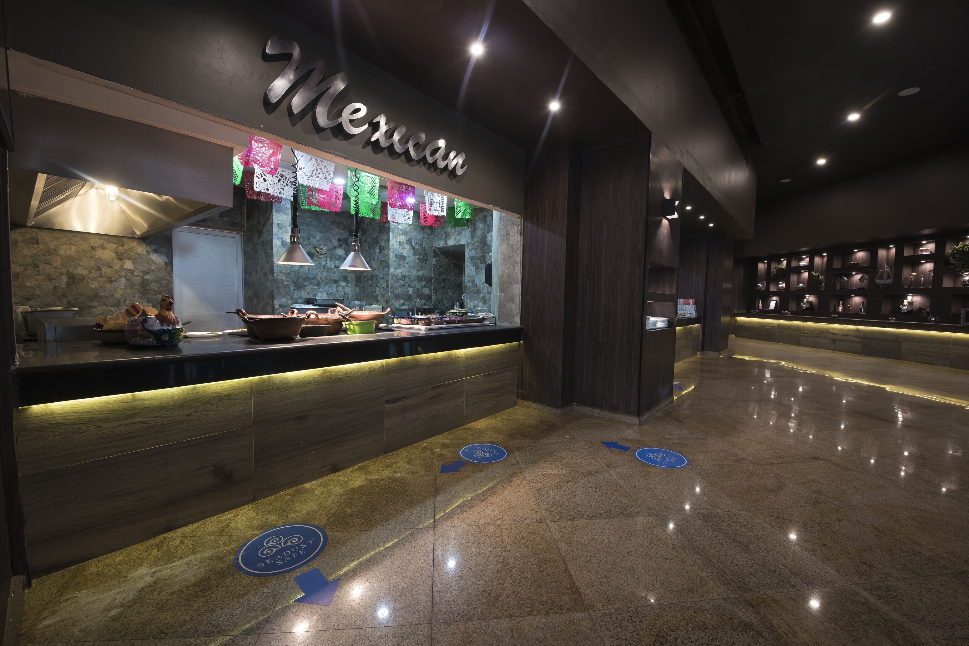 Un restaurante mexicano moderno con un interior oscuro, una barra de madera y un revestimiento de piedra.