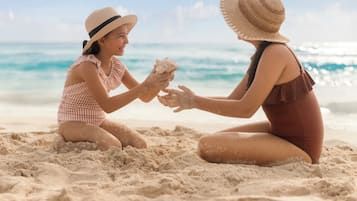 Dos personas jugando con arena en una playa.