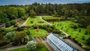 A well-maintained garden with a greenhouse, neatly trimmed hedges, and a variety of trees. - Trump International Golf Links And Hotel Doonbeg Ireland (Doonbeg)