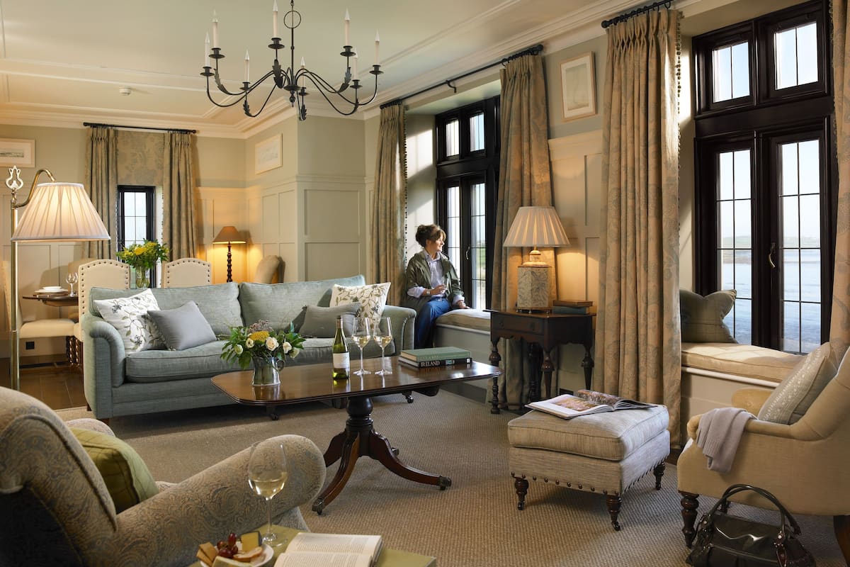 A well-appointed living room with a sofa, armchairs, a coffee table, and a chandelier.
