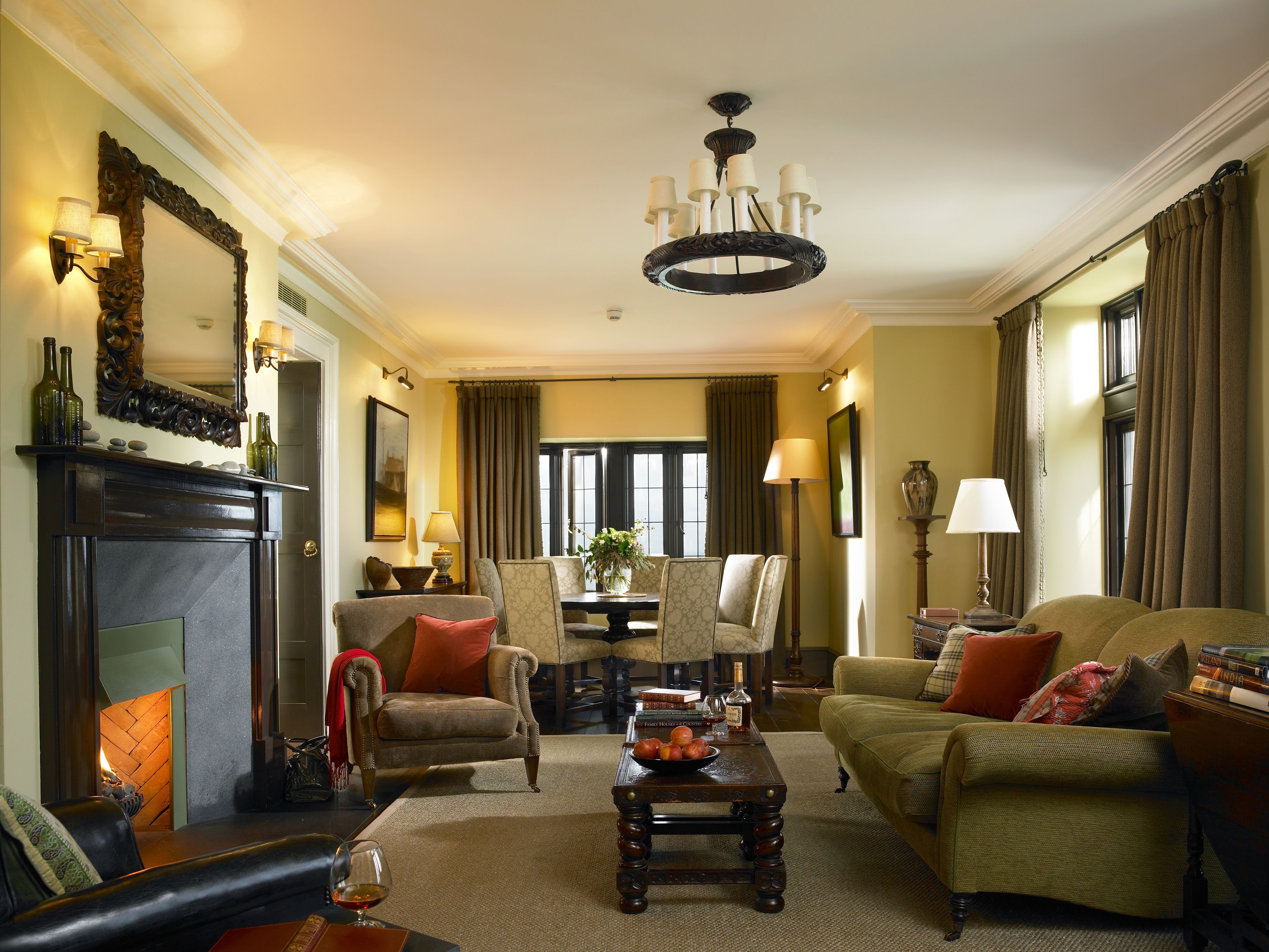 A traditional living room with a fireplace, comfortable seating, and a chandelier.