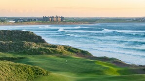 A coastal golf course with a view of the ocean and a distant building. - Trump International Golf Links And Hotel Doonbeg Ireland (Doonbeg)