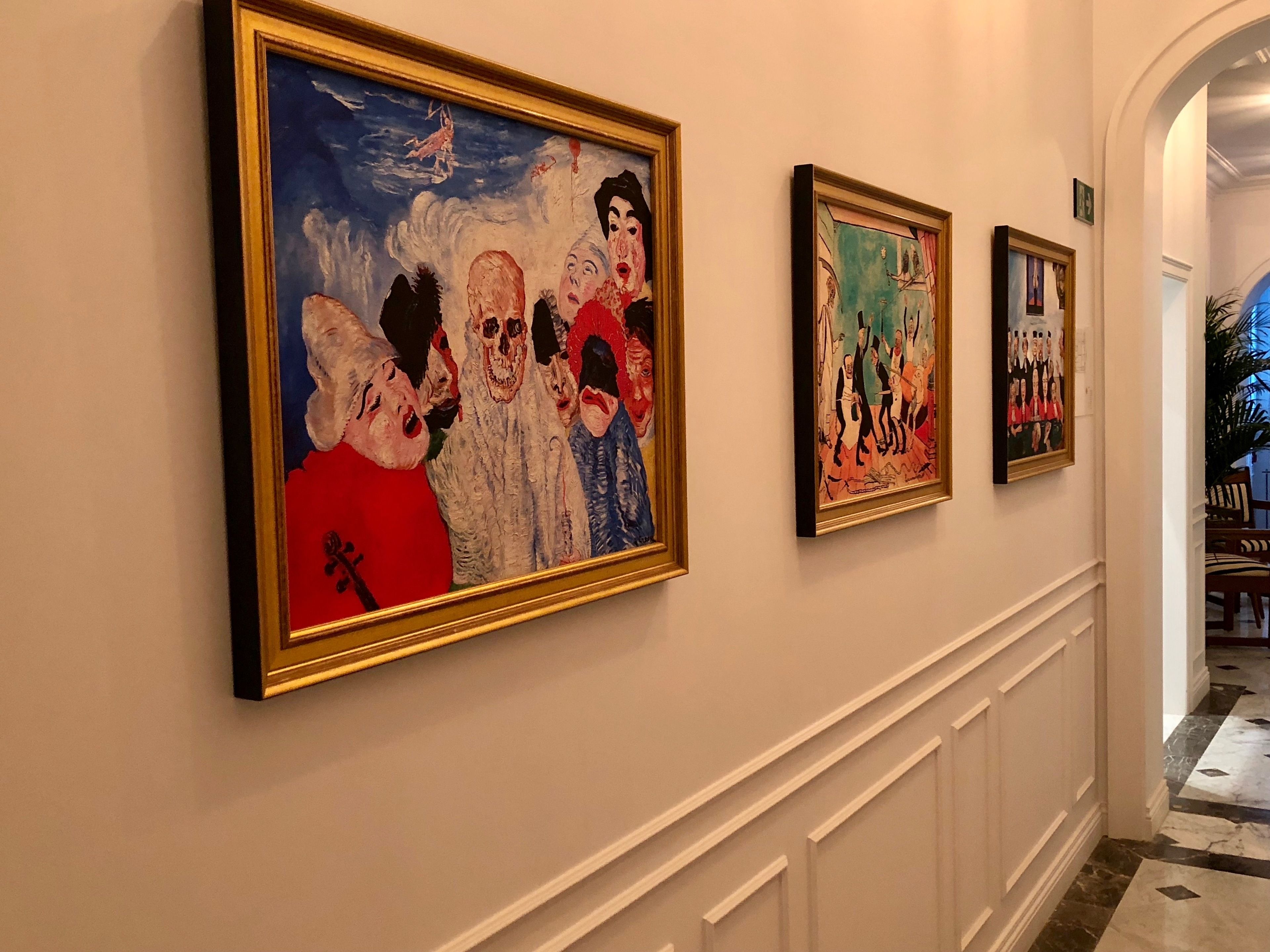 A hallway with three framed artworks on the wall.
