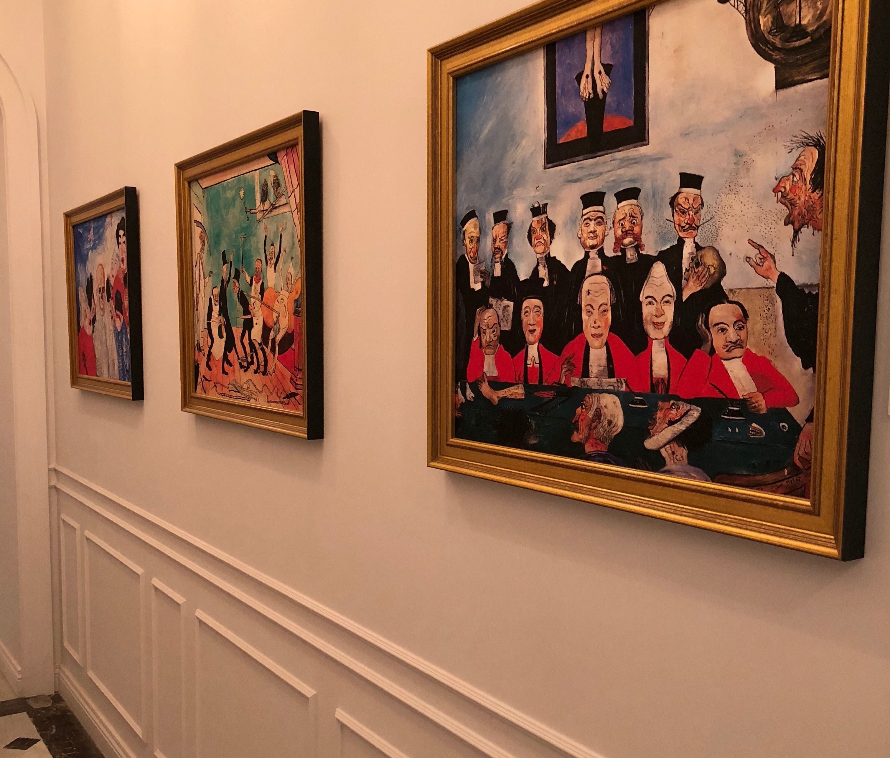 A hallway with three framed artworks on the wall.