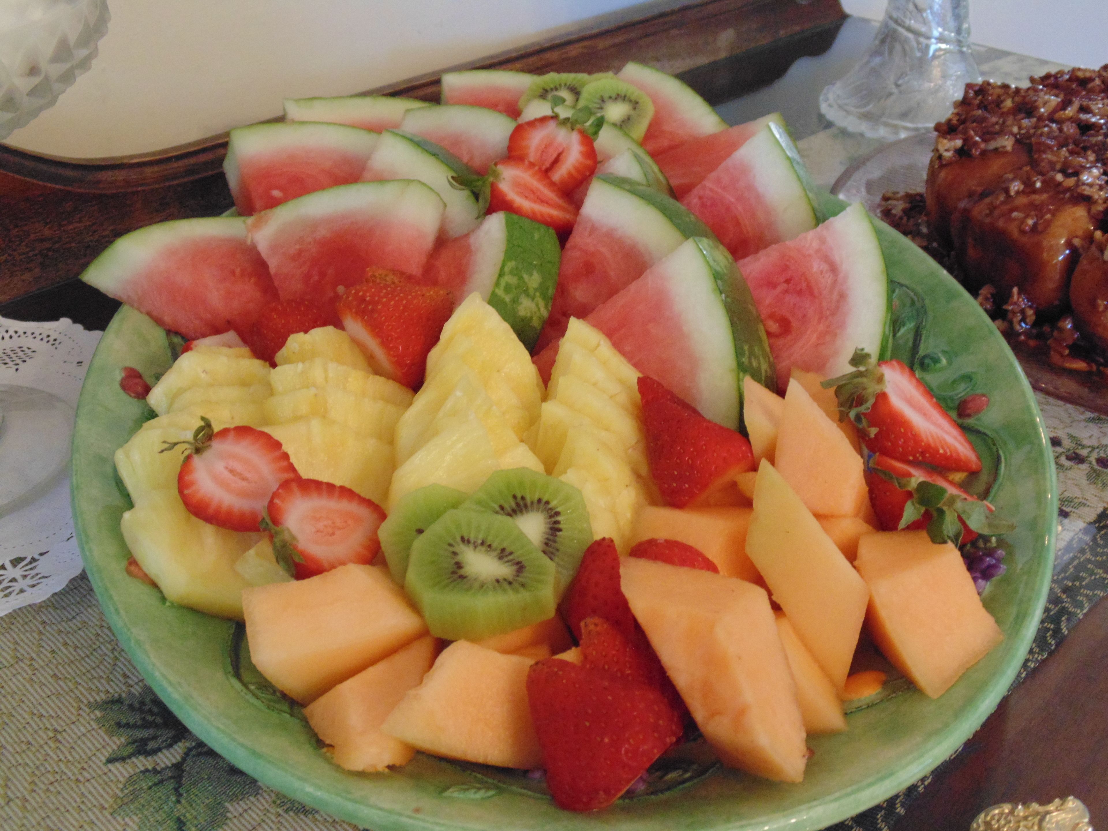 A bowl of assorted fruits including watermelon, strawberries, kiwi, pineapple, and cantaloupe.