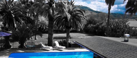 Una piscina al aire libre, tumbonas