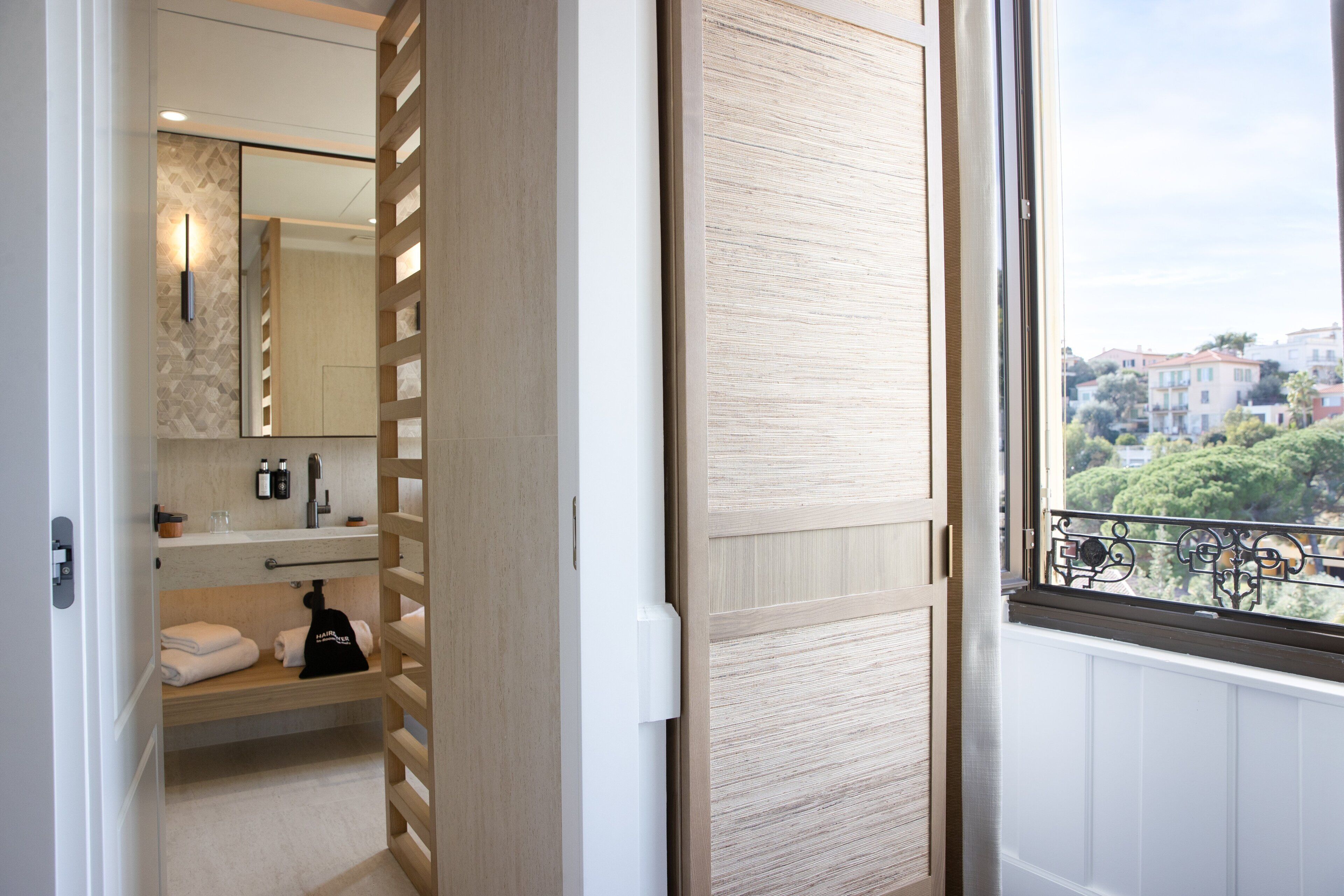 A bathroom with a mirror, sink, and towel rack.