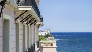 Un immeuble doté de balcons donnant sur la mer, avec une rangée de fenêtres et une vue sur l’océan.
