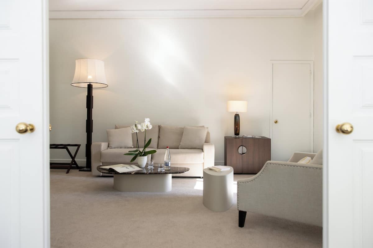 A modern living room with a sofa, coffee table, lamps, and a side table.
