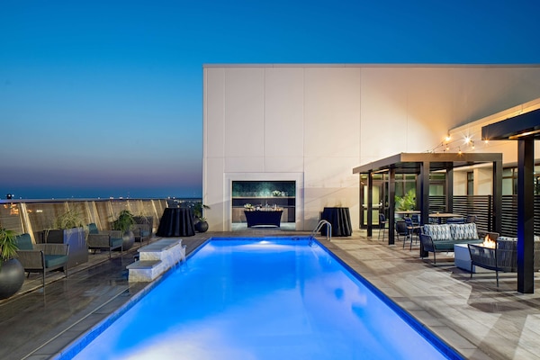 Una piscina al aire libre, sillones reclinables de piscina