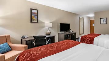 Habitación de hotel con dos camas, un escritorio con computadora, un televisor y una silla.