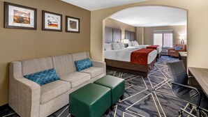 A hotel room with a bed, a sofa, a desk, and a chair. There are three framed pictures on the wall. - Comfort Inn & Suites Lubbock West (Lubbock)