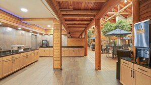 A spacious kitchen with wooden cabinets, a refrigerator, and a dining area with outdoor seating. - C'mon Inn Bozeman (Bozeman)
