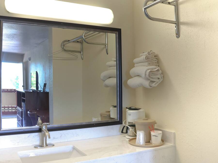 Een bad/douchecombinatie, een haardroger, handdoeken